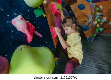 Little Girl Climber Training In A Modern Indoor Rock Climbing Gym. Kids Sport Activities. Selective Focus.