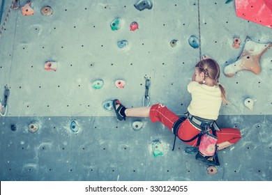 Little Girl Climbing A Rock Wall Indoor