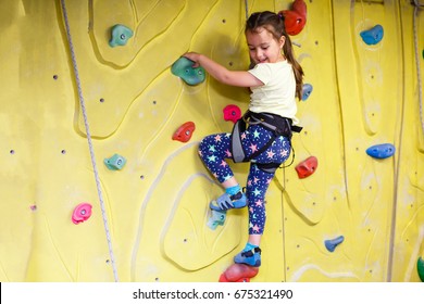 Little Girl Climbing A Rock Wall Indoor