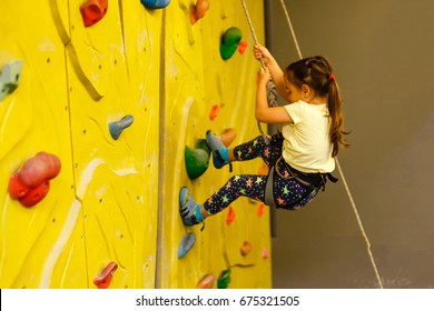 Little Girl Climbing A Rock Wall Indoor