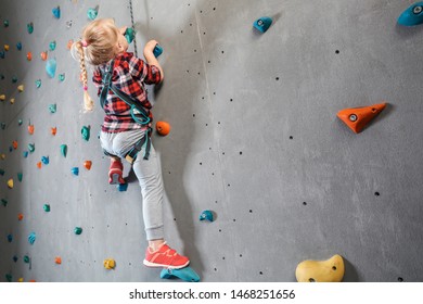 Little Girl Climbing Wall In Gym