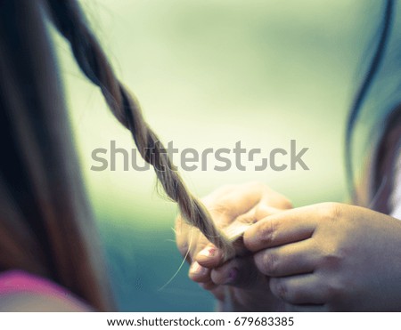 Little girl is combing her mother's hair. Love and family concept.