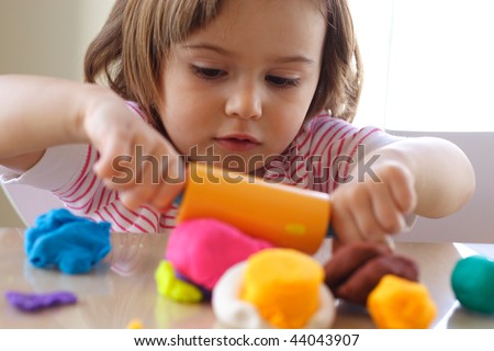 Little girl creating toys from play dough