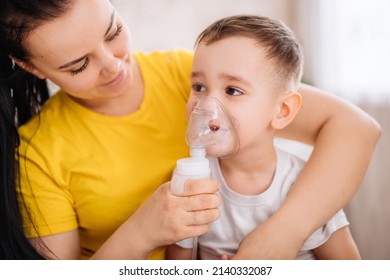 a little girl cries when inhaled with a nebulizer. A child with a viral disease in an inhalation mask is sitting in his mother's arms. Patient with asthma.