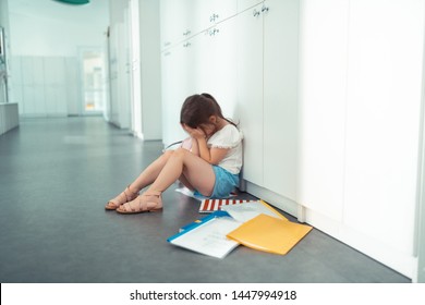 Little Girl Crying. Little Girl Sitting On The Floor Crying After Awful First Day At School With Mockery