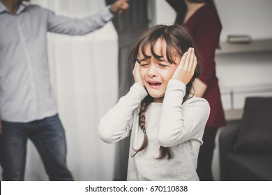 Little girl crying while parents quarrel. Closing the ears, 5-10 years old, vintage tone.