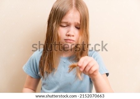 the little girl cuts her own hair. life hacks for hair care. shampoos and vitamins for scalp and hair.