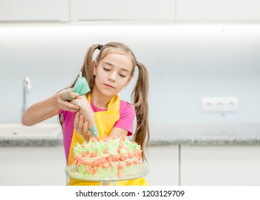 little girl decorating cake in the kitchen at home. Empty space for text - Powered by Shutterstock