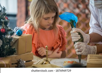 Little Girl Decorating Christmas Biscuits And Gingerbread Cookies In Kitchen Together With Chef. Kids Cooking Class. Merry Christmas And Happy Holidays Concept