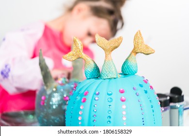 Little Girl Decorating Her Halloween Pumpkin With Rhinestones.