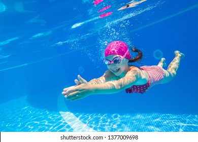 Kleines Mädchen schwimmt unter Wasser im Pool