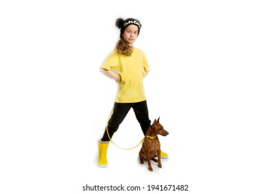 Little Girl With Dog, Black And Yellow Clothes. White Background. Studio Shooting. Baby Pets Concept. Happy Childhood