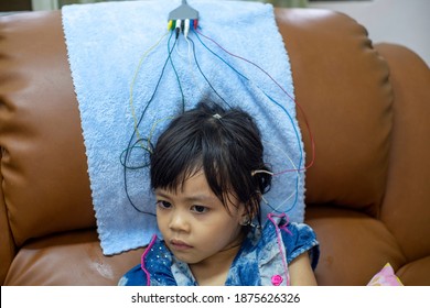 A Little Girl Is Doing A Neurofeedback Exam. Making EEG Electrodes.