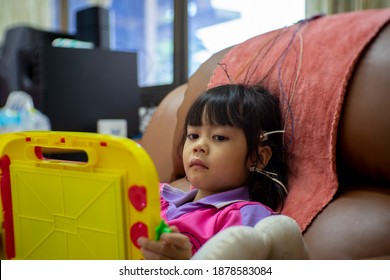 A Little Girl Is Doing A Neurofeedback Exam. Making EEG Electrodes.