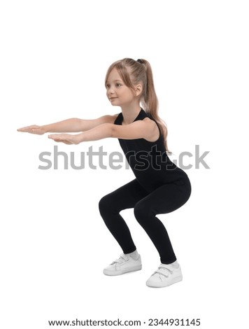 Little girl doing squats on white background. Morning exercise