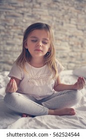 Little Girl Doing Yoga In Bed. 