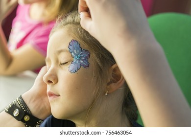 little girl draw butterfly her face