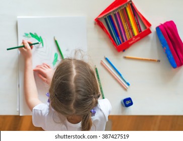 Little Girl Drawing With Pencil At Home. Top View.