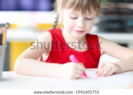 Little girl drawing with pink felttip pen