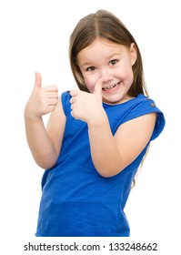Little girl dressed in blue is showing thumb up gesture using both hands, isolated over white