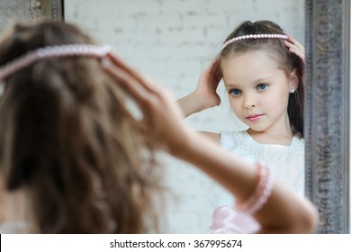 Little Girl Dresses Up Front Of The Mirror. Cute Princess In Beautiful Dress And Necklece. 