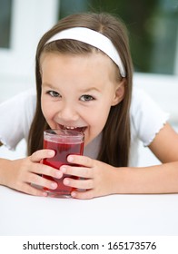 Little Girl Is Drinking Cherry Juice Using Straw