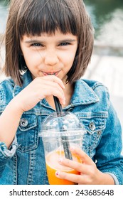 Little Girl Drinking A Fruit Smoothie In The Street