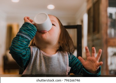 Little Girl Drinking Mug Of Hot Chocolate