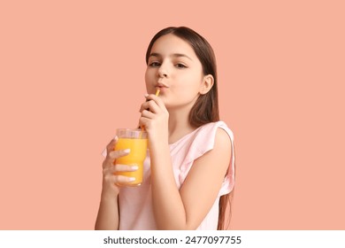 Little girl drinking orange juice on pink background - Powered by Shutterstock