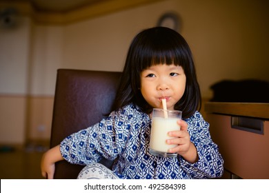 Little Girl Drinking Soy Milk From A Cup With A Straw,Cute Little Girl Drinks Milk Using A Drinking Straw