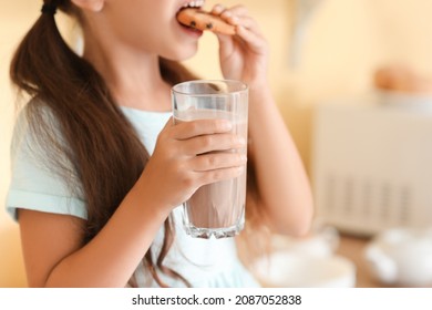 Little Girl Drinking Tasty Chocolate Milk And Eating Cookies At Home