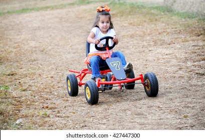 Little Girl Drives A Go Cart On A Dirt Track In Tennessee.  She Has A Determined Look On Her Face As She Gives It Her All.