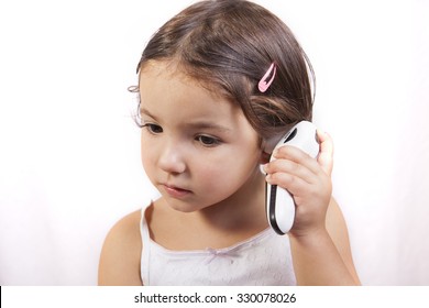 Little girl with ear talking electronic thermometer taking herself the temperature. Isolated over white background - Shutterstock ID 330078026