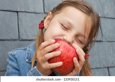 Little Girl Eating An Apple