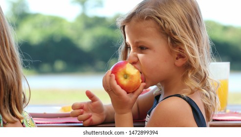 
Little Girl Eating Apple Fruit Child Taking A Bite Of Apple