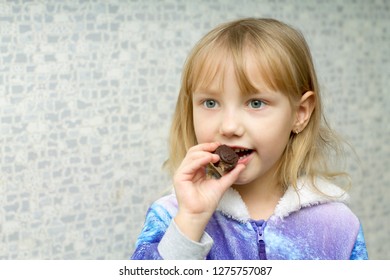 little girl eating chocolate candy in the form of a lion cub of black chocolate