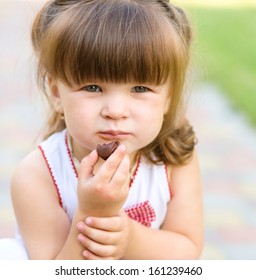 Little Girl Is Eating Chocolate Candy, Outdoor Shoot