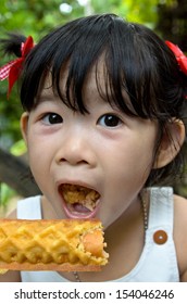 Little Girl Eating A Corn Dog.Kid Eating Corn Dog.