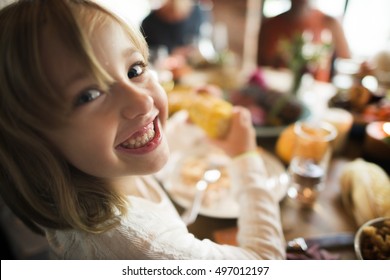 Little Girl Eating Corn Thanksgiving Celebration Concept