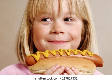 Little girl eating a hot dog.Kid eating hot dog.