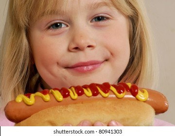 Little Girl Eating A Hot Dog.Kid Eating Hot Dog.