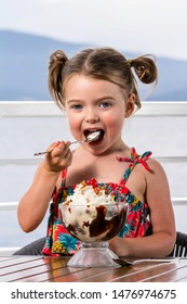 Little Girl Eating A Large Ice Cream Sundae Lake Side In Coeur D' Alene Idaho