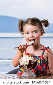 Little Girl Eating A Large Ice Cream Sundae Lake Side In Coeur D' Alene Idaho