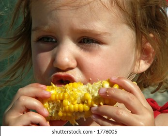 Little Girl Eating Messy Corn On The Cob