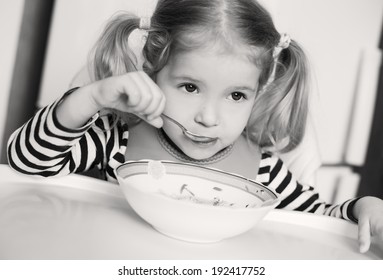 Little Girl Eating Soup On A White Background ( Black And White )