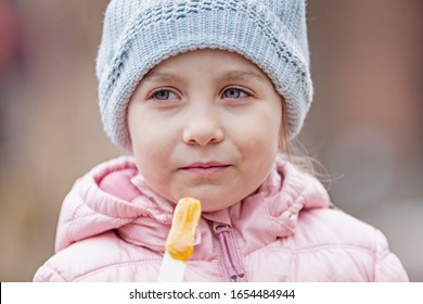 Little Girl Eating Traditional Maple Syrup Taffy Candy At Outdoor Public Spring Festival In Quebec, Canada. Selective Focus On Face.