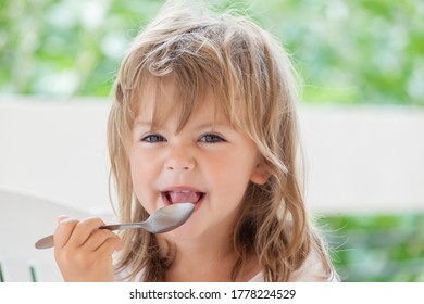 little girl eats honey with a spoon