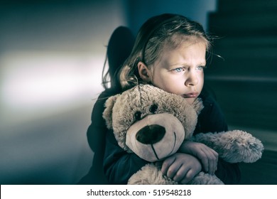 Little girl embracing her teddy bear - feels lonely -  if you are small sad girl teddy bear is willing to be your best friend - instagram filter applied