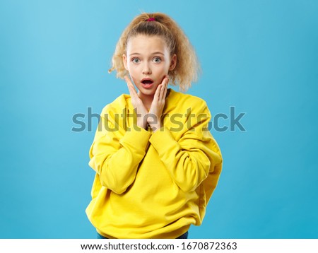 Little girl emotions studio lifestyle yellow sweater blue background fashion