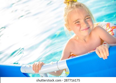 Little Girl Enjoying Backyard Swimming Pool. Summertime Water Fun. 